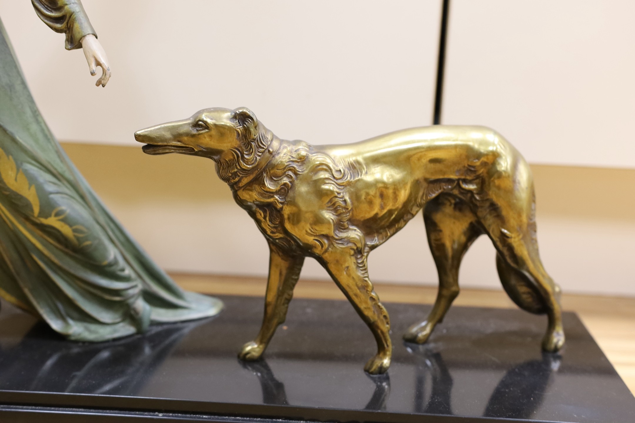 A French Art Deco female spelter figure and two bronzed spelter dogs on black marble base, signed Roggia. 74cm wide